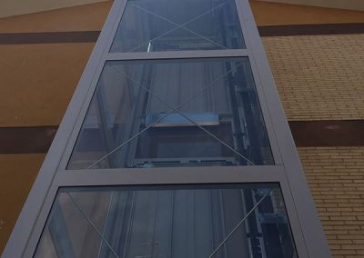 piattaforma elevatrice idraulica con incastellatura in ferro verniciato portante da esterno con porte automatiche visuale dal basso